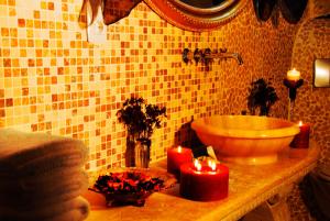 a bathroom with a sink and two candles on a counter at Perimasali Cave Hotel - Cappadocia in Ürgüp