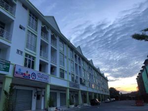 a large white building with a sunset in the background at Medina Homestay, Wakaf Che Yeh in Kota Bharu