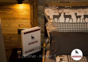 a bed with a book and a bed with a poster of deer at Gästehaus Branders in Namlos