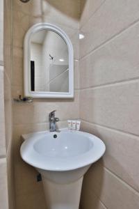 نجمة نوارة للوحدات الفندقية في نجران: حمام مع حوض أبيض ومرآة