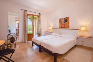 een slaapkamer met een bed, een tafel en stoelen bij Finca Xemarri in Santanyi +61 foto's