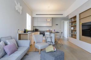 a living room with a couch and a kitchen at Italian design apartment in Rotchild /habima in Tel Aviv