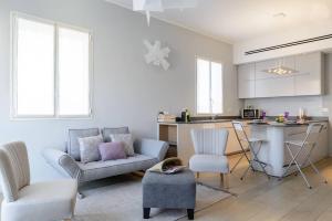 Una sala de estar con un sofá y una mesa y una cocina. en Italian design apartment in Rothschild Blvd, en Tel Aviv