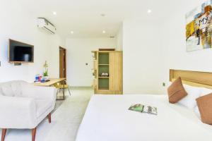 a bedroom with a bed and a chair and a desk at Annie Danang Hotel & Apartment in Danang +14 photos