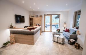 a living room with a kitchen and a couch at Hotel Garni Isarlodge Wiesenhof in Scharnitz