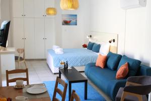 - un salon avec un canapé bleu et un lit dans l'établissement 4YOU STUDIOS, à Larnaka