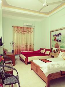 a bedroom with two beds and a table and chairs at Thien An Guest House in Yên Minh