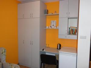 a kitchen with white cabinets and a desk at Apartment Moni in Veliko Tŭrnovo