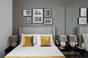 sypialnia z dużym białym łóżkiem z żółtymi poduszkami w obiekcie Nevern Place by Supercity Aparthotels w Londynie