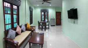 a living room with a couch and a tv at Anacar Bungalows in Krabi town