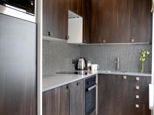 a kitchen with wooden cabinets and a stove top oven at Nevern Place by Supercity Aparthotels in London