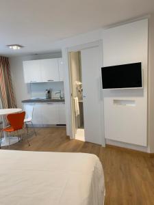um quarto com uma cama e uma cozinha com uma televisão em BB Hotels Aparthotel Isola em Milão