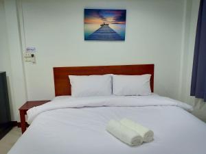 un grande letto bianco con un asciugamano bianco sopra di ณ สุข รีสอร์ท (Nasuk resort) a Khon Kaen