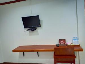 a desk with a television on a white wall at ณ สุข รีสอร์ท (Nasuk resort) in Khon Kaen