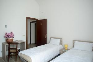 a bedroom with two beds and a table with a chair at IL TRAMONTO SUL PO in Calendasco