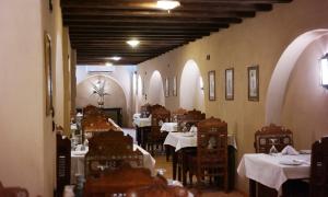 un comedor con mesas blancas, sillas y arcos en Djorff Palace en Luxor