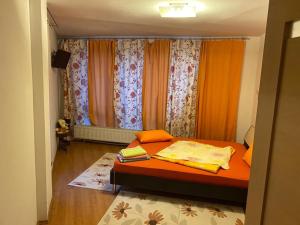 a bedroom with a bed with orange sheets and curtains at Villa Predeal in Predeal +27 photos
