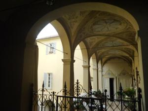 an archway leading into a building with a fence at Luisa in Palazzo Bianchi in Parma
