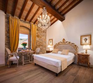 a bedroom with a bed and a table and a chandelier at Agri Resort & SPA Le Colline del Paradiso in Vaglia