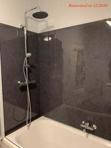 a bathroom with a bath tub with a shower at Villa Sint Anna in Sint Anna ter Muiden
