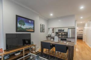 a living room with a table and a large television at Beautiful 2 bedroom-Graduate Hospital-Back Patio in Philadelphia