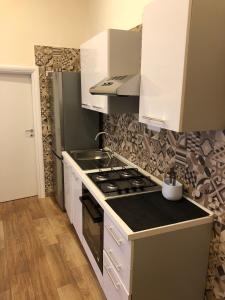 a kitchen with white cabinets and a stove top oven at Il Paradiso di Dante in Naples