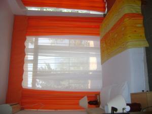 ein Fenster mit orangefarbenem Blind in einem Zimmer in der Unterkunft Arabela Apartments in Utjeha