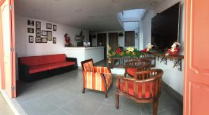 a living room with a red couch and chairs at Hotel Saval Jerico in Jericó