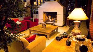 uma sala de estar com uma lareira, um sofá e uma mesa em Pousada Arraial do Ouro em Gaspar