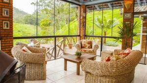 a screened in porch with chairs and a table at Pousada Arraial do Ouro in Gaspar