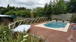 a small swimming pool in a yard with a fence at Cabañas El Descanso in Villa Santa Cruz del Lago
