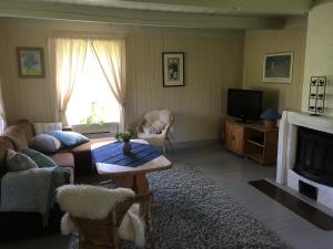 a living room with a couch and a table and a tv at Staurheim gård in Bø