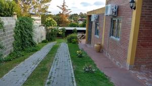 un jardín con un edificio de ladrillo y un patio de ladrillo en Cabañas El Descanso en Villa Santa Cruz del Lago
