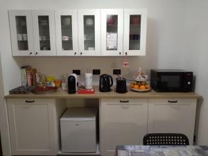 een keuken met witte kasten en een aanrecht met een magnetron bij Bed and Breakfast Relax in Trento