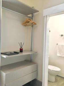 a bathroom with a toilet and a shelf at Waterfront Inn in Shanklin