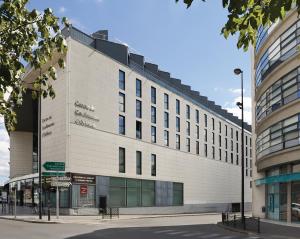 - un grand bâtiment blanc dans une rue de la ville dans l'établissement Séjours & Affaires Orléans Jeanne D'Arc, à Orléans