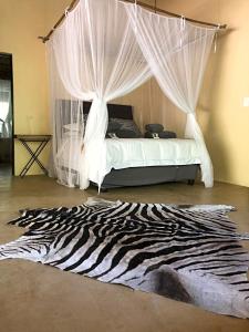 a bedroom with a bed with a zebra rug at Lion Hill @Kruger in Marloth Park