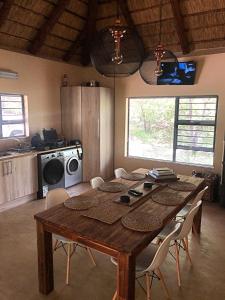 a dining room table with chairs and a kitchen at Lion Hill @Kruger in Marloth Park +28 photos