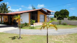 une maison avec un palmier en face dans l'établissement Pousada O Tabuleiro, à Jacumã