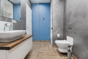 La salle de bains est pourvue d'un lavabo blanc et de toilettes. dans l'établissement CityApartments Kyiv Akademmistechko, à Kiev