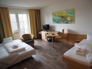 ein Hotelzimmer mit 2 Betten und einem Schreibtisch in der Unterkunft Hotel Xylophon - inklusive Thermeneintritte in Lutzmannsburg