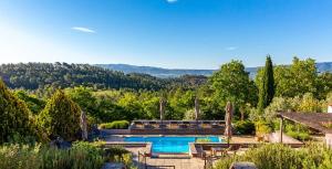 a swimming pool in the middle of a garden at Le Chant du Coeur in Roussillon