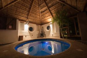 a swimming pool in a house with a roof at Hotel La Aldea in San Pedro de Atacama