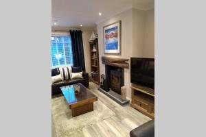 a living room with a couch and a television at THE ANCHORAGE in Arrochar