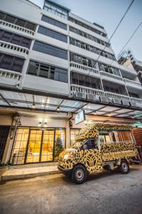 a large yellow truck parked in front of a building at Theme Boutique Hotel Bangkok in Bangkok