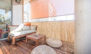 ein Wohnzimmer mit einem Sofa und einem Tisch auf dem Balkon in der Unterkunft Magnificent apartment close to the beach in Barcelona