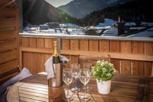a bottle of wine sitting on a table with wine glasses at Appartamento Lusso Panoramic - Andalo in Andalo