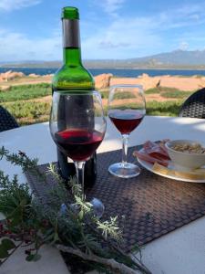 Una botella de vino y dos copas en una mesa. en Residences La Tonnara, en Bonifacio