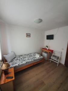 a bedroom with a bed and a desk and a television at Тодор Прегьов in Bansko