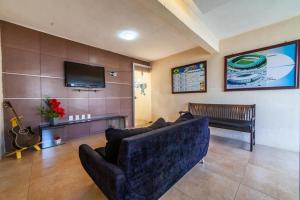 a living room with a couch and a flat screen tv at Flats Gol de Placa in Fortaleza